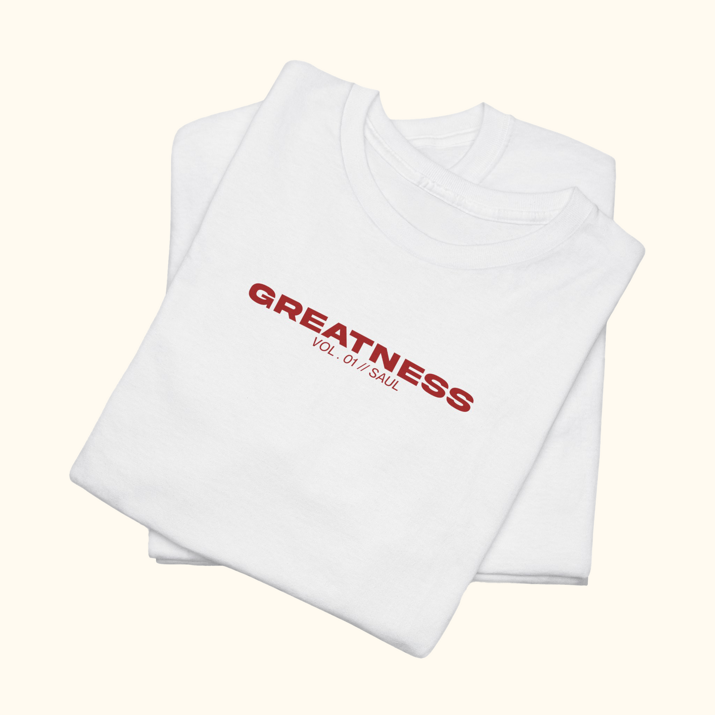 White t-shirt with red text 'GREATNESS' on the chest